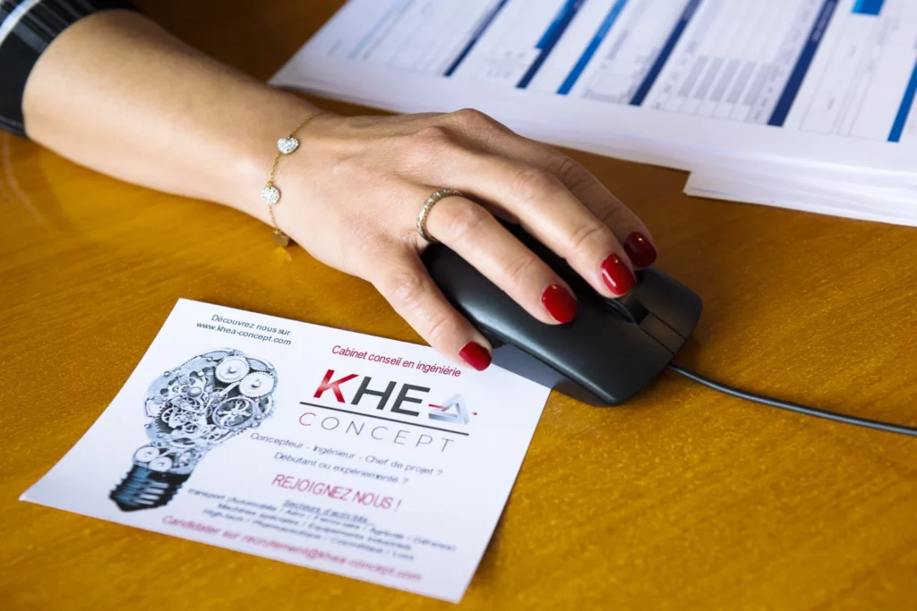 une main tenant une souris sur un bureau avec un flyer khea concept