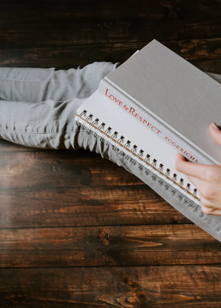 personne assise par terre avec livre sur les jambes